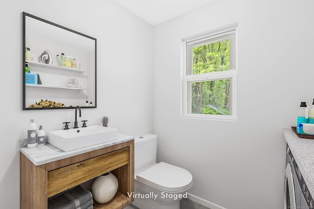 33 Hurlbut Rd, Tolland, CT 06084 - half bathroom with vanity, toilet, baseboards, and washer / dryer