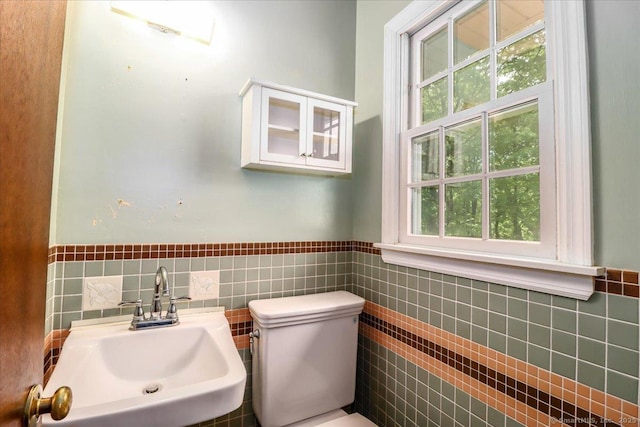 31 Buckingham Rd, New Milford, CT 06776 - bathroom with tile walls, a sink, toilet, and a wainscoted wall