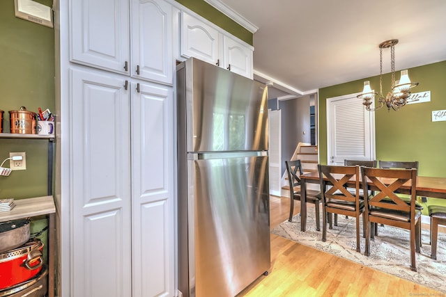54 Mariot Cir, Wallingford, CT 06492 - kitchen with freestanding refrigerator, white cabinets, light wood finished floors, hanging light fixtures, and a chandelier