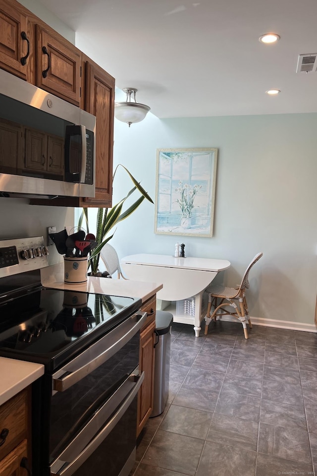123 Old Belden Hill Rd Apt 5, Norwalk, CT 06850 - kitchen featuring stainless steel appliances, light countertops, baseboards, recessed lighting, and brown cabinetry