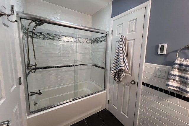 123 Old Belden Hill Rd Apt 5, Norwalk, CT 06850 - full bathroom featuring combined bath / shower with glass door, wainscoting, tile patterned flooring, and tile walls