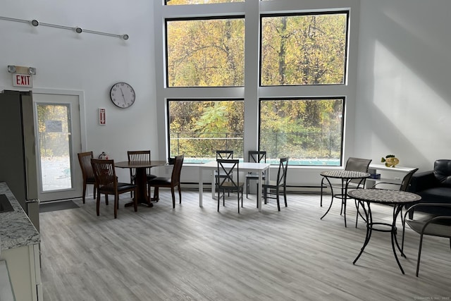 123 Old Belden Hill Rd Apt 5, Norwalk, CT 06850 - dining room featuring a towering ceiling, light wood-style flooring, and healthy amount of natural light