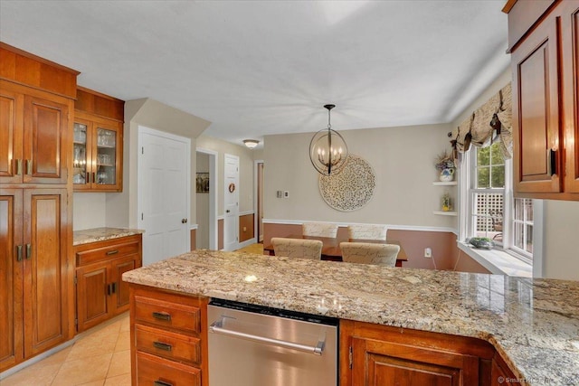 190 Bronson Dr, Middlebury, CT 06762 - kitchen with stainless steel dishwasher, brown cabinets, light stone countertops, and a chandelier