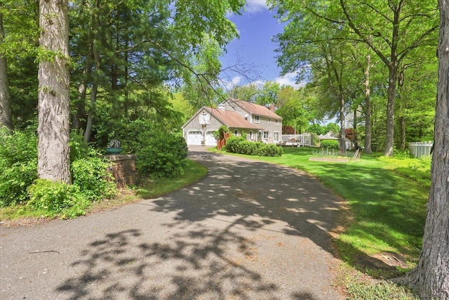 190 Bronson Dr, Middlebury, CT 06762 - view of front of house with asphalt driveway, a front yard, and a chimney