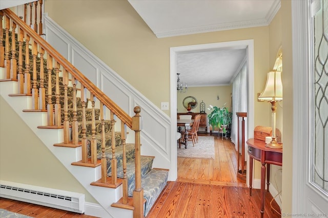 190 Bronson Dr, Middlebury, CT 06762 - stairway with a baseboard radiator, ornamental molding, wood-type flooring, and a chandelier