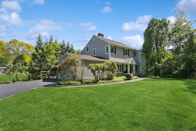 11 Valley Rd, Westport, CT 06880 - view of front of house with a chimney, a front yard, asphalt driveway, and a shingled roof