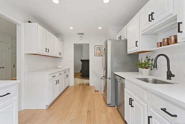 11 Valley Rd, Westport, CT 06880 - kitchen with dishwasher, a sink, white cabinets, recessed lighting, and light wood-style flooring