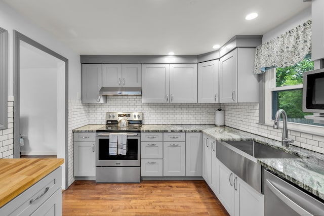 239 Old Field Ln, Milford, CT 06460 - kitchen with stainless steel appliances, a sink, decorative backsplash, light stone counters, and recessed lighting