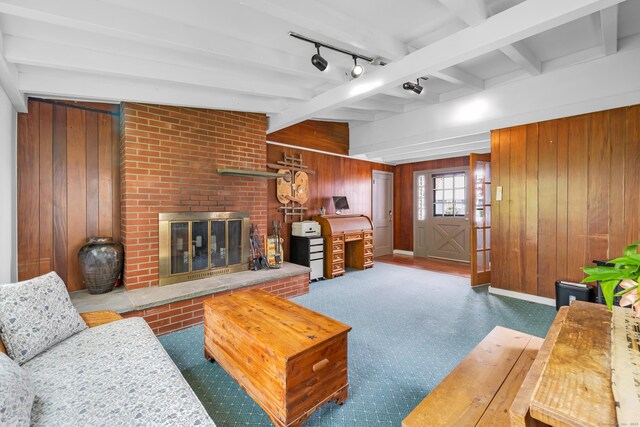 239 Old Field Ln, Milford, CT 06460 - living room featuring wood walls, beamed ceiling, a brick fireplace, rail lighting, and baseboards