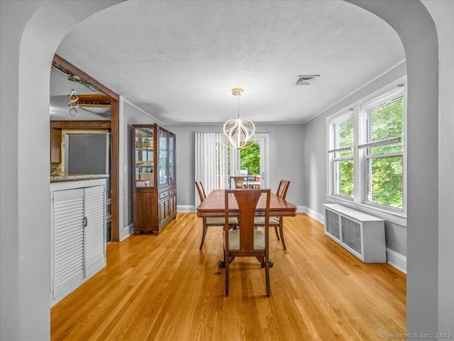 18 Geer Ave, Norwich, CT 06360 - dining room with arched walkways, a chandelier, radiator, light wood-style floors, and baseboards