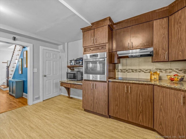 18 Geer Ave, Norwich, CT 06360 - kitchen with stainless steel appliances, under cabinet range hood, decorative backsplash, light wood-style flooring, and light stone countertops