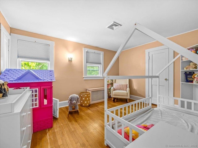 18 Geer Ave, Norwich, CT 06360 - bedroom featuring multiple windows, hardwood / wood-style flooring, baseboards, and radiator heating unit