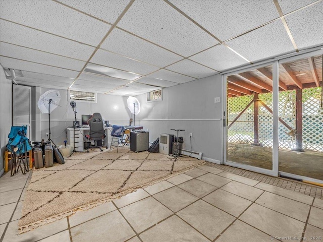 18 Geer Ave, Norwich, CT 06360 - basement featuring tile patterned flooring, a paneled ceiling, plenty of natural light, and a baseboard radiator