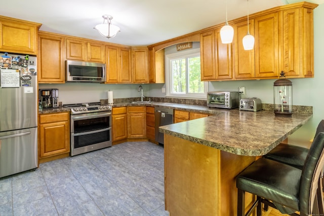 55 Linton St, Torrington, CT 06790 - kitchen featuring stainless steel appliances, a sink, dark countertops, and a peninsula