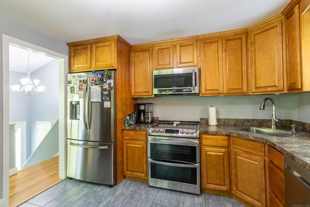 55 Linton St, Torrington, CT 06790 - kitchen featuring appliances with stainless steel finishes, a sink, brown cabinetry, and a chandelier