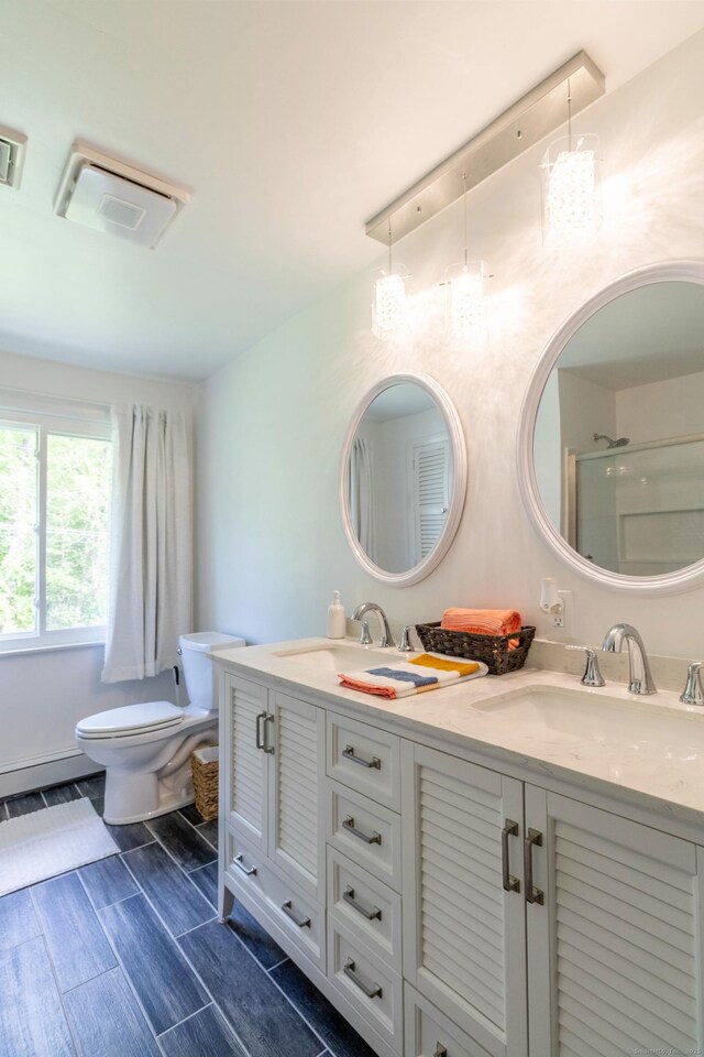 55 Linton St, Torrington, CT 06790 - bathroom with double vanity, toilet, a baseboard heating unit, and an enclosed shower