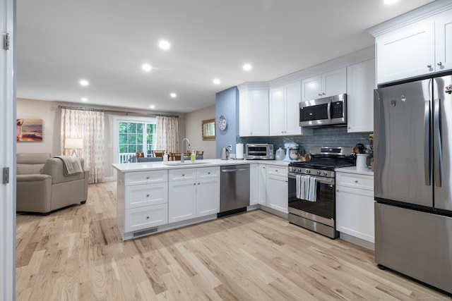 21 Summer Brook Way, Seymour, CT 06483 - kitchen with appliances with stainless steel finishes, a sink, a peninsula, light wood finished floors, and recessed lighting