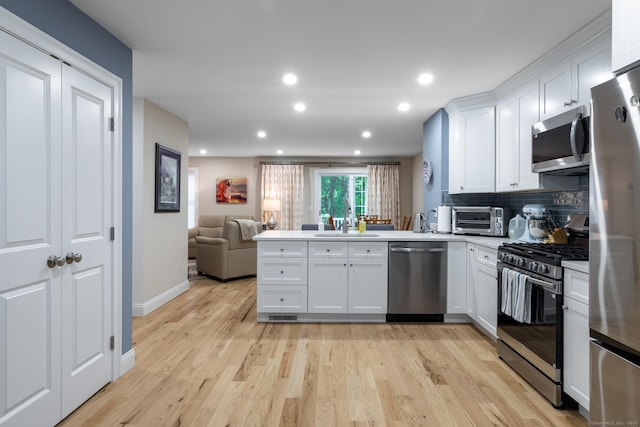 21 Summer Brook Way, Seymour, CT 06483 - kitchen featuring stainless steel appliances, open floor plan, a peninsula, white cabinetry, and a sink