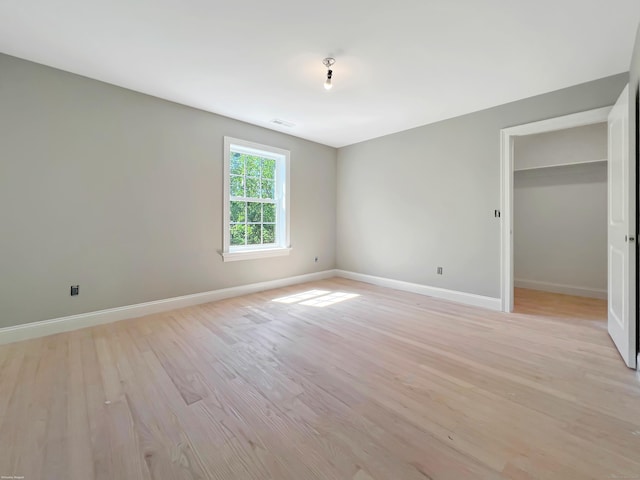 67 Fairfield Pl, Beacon Falls, CT 06403 - unfurnished bedroom featuring baseboards, light wood finished floors, and a walk in closet