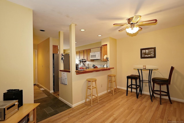 62 Deer Run Unit 62, Bethel, CT 06801 - kitchen with white microwave, wood finished floors, a kitchen bar, a ceiling fan, and recessed lighting