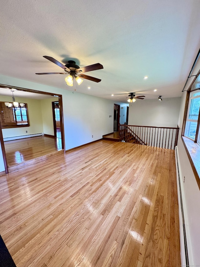 588 Poquonock Ave, Windsor, CT 06095 - unfurnished room featuring a baseboard radiator, baseboard heating, a ceiling fan, light wood-style floors, and healthy amount of natural light