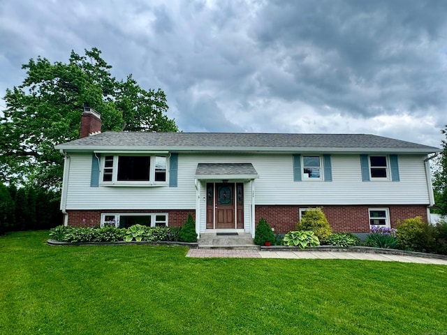 588 Poquonock Ave, Windsor, CT 06095 - split foyer home featuring a front yard, a chimney, and brick siding
