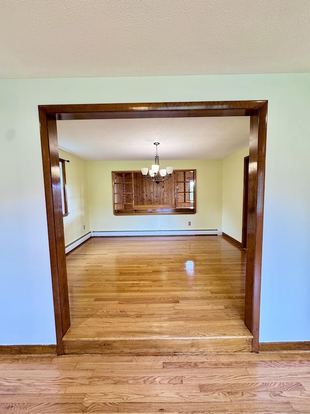 588 Poquonock Ave, Windsor, CT 06095 - unfurnished dining area featuring wood finished floors, a chandelier, and baseboards