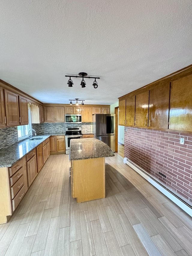 588 Poquonock Ave, Windsor, CT 06095 - kitchen with stainless steel appliances, a baseboard heating unit, light wood-style floors, a kitchen island, and a textured ceiling