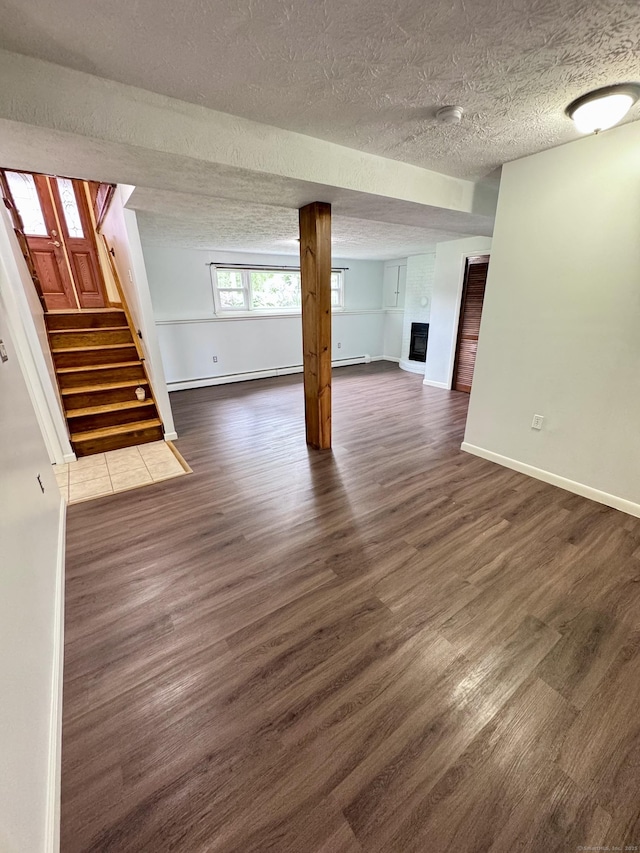 588 Poquonock Ave, Windsor, CT 06095 - basement with a textured ceiling, dark wood-type flooring, stairway, baseboards, and a baseboard radiator
