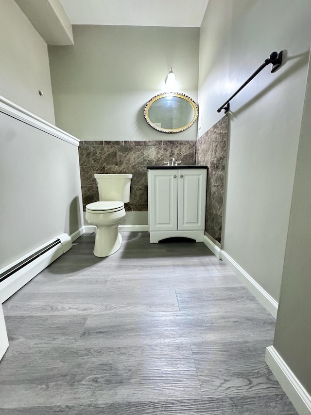 588 Poquonock Ave, Windsor, CT 06095 - bathroom featuring toilet, tile walls, vanity, wood finished floors, and a baseboard radiator