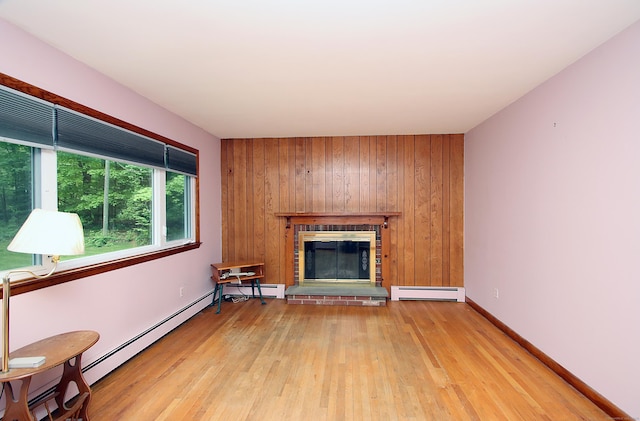 179 N Moodus Rd, East Haddam, CT 06469 - unfurnished living room featuring baseboard heating, a fireplace, light wood finished floors, wood walls, and baseboards