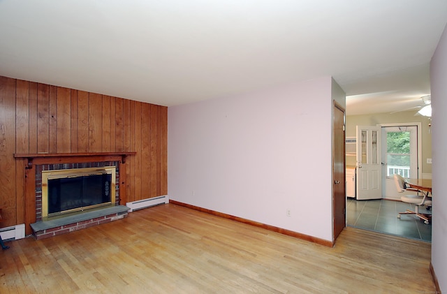 179 N Moodus Rd, East Haddam, CT 06469 - unfurnished living room with a baseboard radiator, light wood-style flooring, a fireplace, a ceiling fan, and baseboards