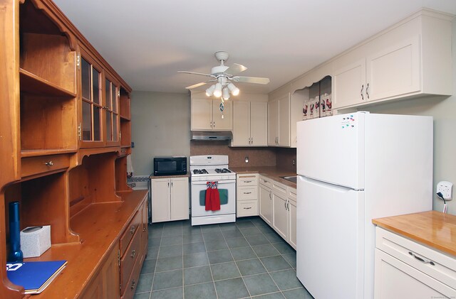 179 N Moodus Rd, East Haddam, CT 06469 - kitchen with white appliances, under cabinet range hood, dark tile patterned floors, ceiling fan, and white cabinetry