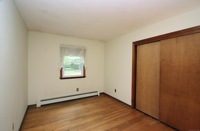 179 N Moodus Rd, East Haddam, CT 06469 - unfurnished bedroom featuring a baseboard heating unit, wood finished floors, a closet, and baseboards