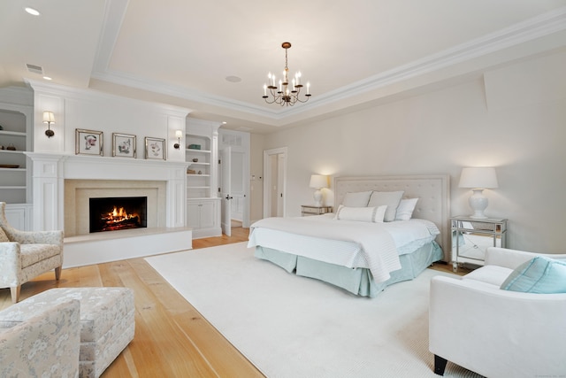 294 Maple Rd, Easton, CT 06612 - bedroom featuring a chandelier, light wood-style flooring, a tray ceiling, crown molding, and a high end fireplace