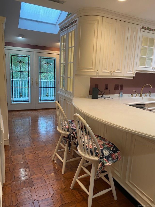 2 Tunxis Pl, Cheshire, CT 06410 - kitchen with a sink, a skylight, glass insert cabinets, and french doors