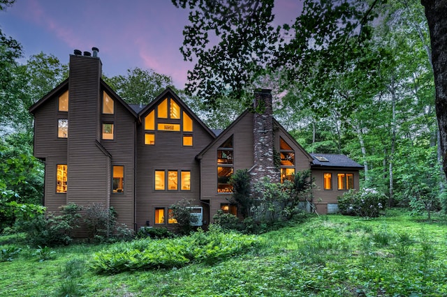 522 Peddlers Rd, Guilford, CT 06437 - back of property at dusk with a chimney