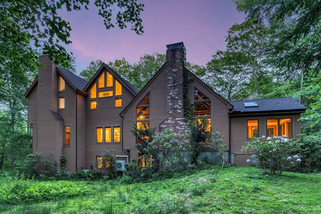 522 Peddlers Rd, Guilford, CT 06437 - back of house at dusk with a chimney, a yard, and a shingled roof
