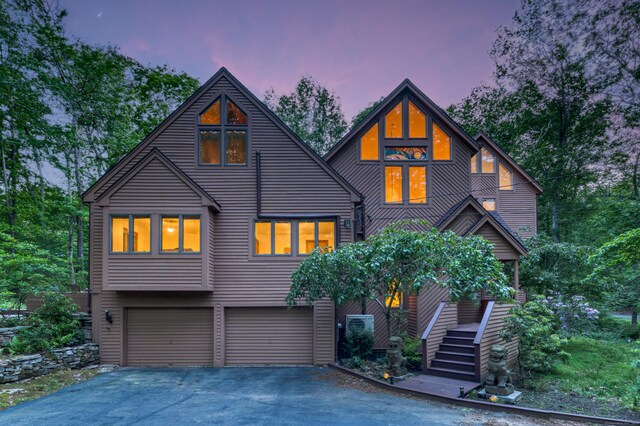 522 Peddlers Rd, Guilford, CT 06437 - rustic home featuring an attached garage, asphalt driveway, and stairway
