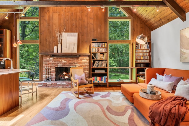 522 Peddlers Rd, Guilford, CT 06437 - living room with wood walls, wooden ceiling, wood finished floors, and a brick fireplace