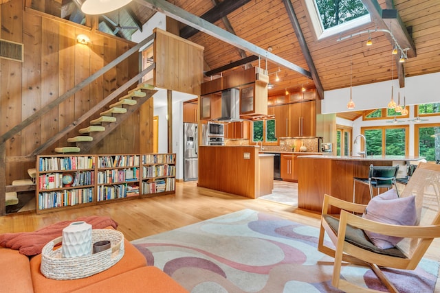 522 Peddlers Rd, Guilford, CT 06437 - living room with a wooden ceiling with exposed beams, a skylight, light wood-style flooring, high vaulted ceiling, and stairs