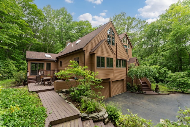 522 Peddlers Rd, Guilford, CT 06437 - rear view of property featuring a deck, a garage, driveway, roof with shingles, and stairway