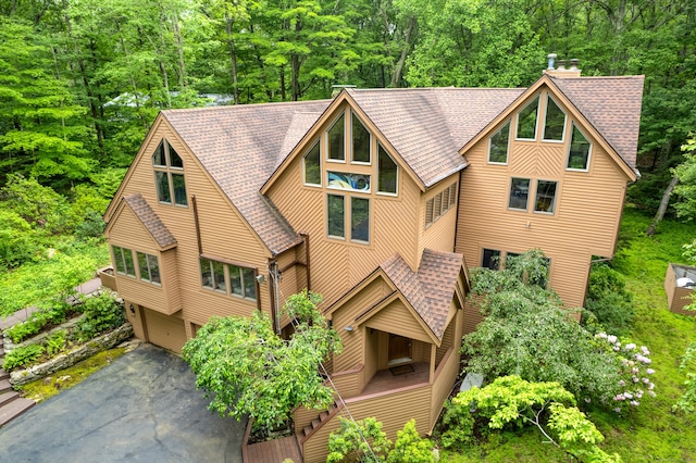 522 Peddlers Rd, Guilford, CT 06437 - view of front of property featuring roof with shingles, an attached garage, asphalt driveway, a wooded view, and a chimney