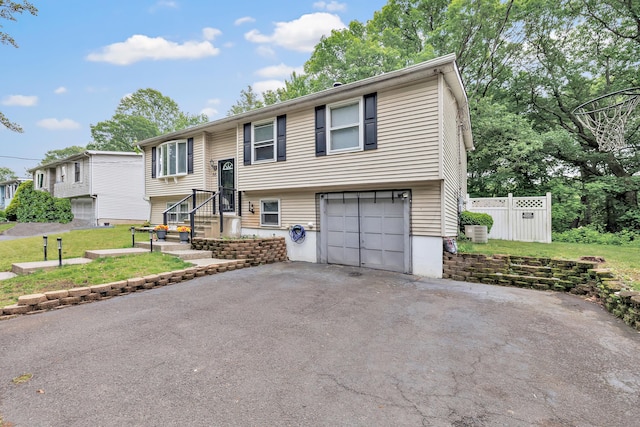 66 Coleman St, West Haven, CT 06516 - bi-level home with asphalt driveway, a garage, and cooling unit