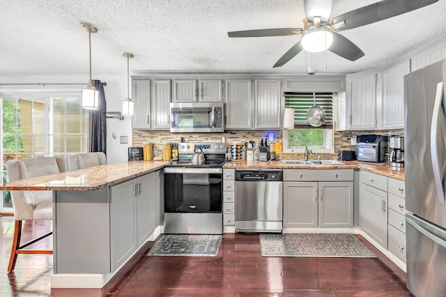 66 Coleman St, West Haven, CT 06516 - kitchen with stainless steel appliances, a peninsula, a textured ceiling, dark wood-type flooring, and a sink