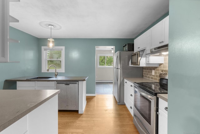 179 Carey Ave, Meriden, CT 06451 - kitchen featuring stainless steel appliances, a sink, under cabinet range hood, white cabinetry, and tasteful backsplash