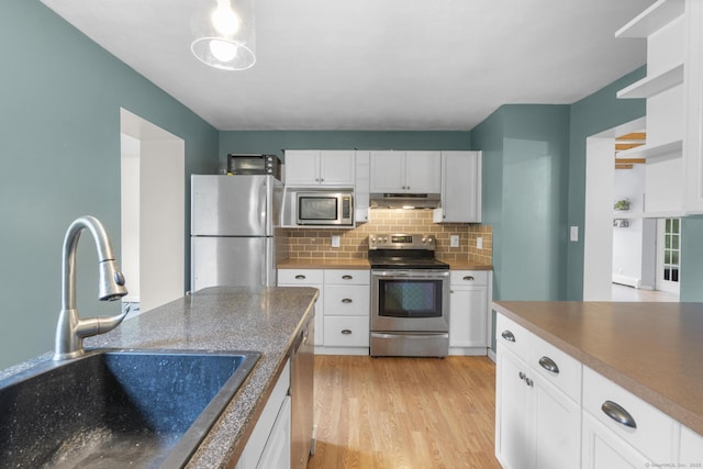179 Carey Ave, Meriden, CT 06451 - kitchen with appliances with stainless steel finishes, a sink, under cabinet range hood, light wood-style flooring, and backsplash