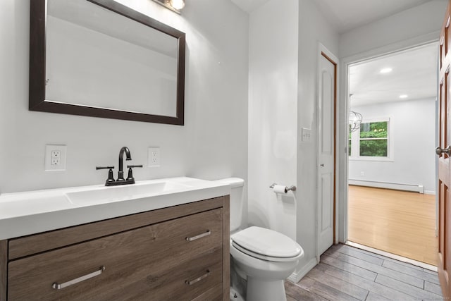 179 Carey Ave, Meriden, CT 06451 - half bathroom with baseboard heating, wood finished floors, toilet, and vanity
