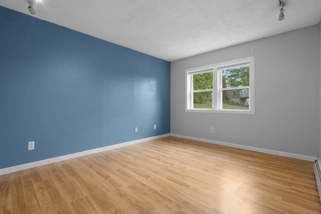 179 Carey Ave, Meriden, CT 06451 - empty room featuring rail lighting, light wood-type flooring, baseboards, and a baseboard radiator