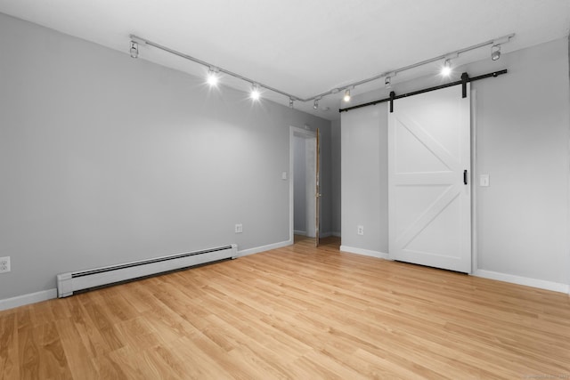 179 Carey Ave, Meriden, CT 06451 - unfurnished bedroom featuring baseboard heating, rail lighting, a barn door, and light wood-type flooring